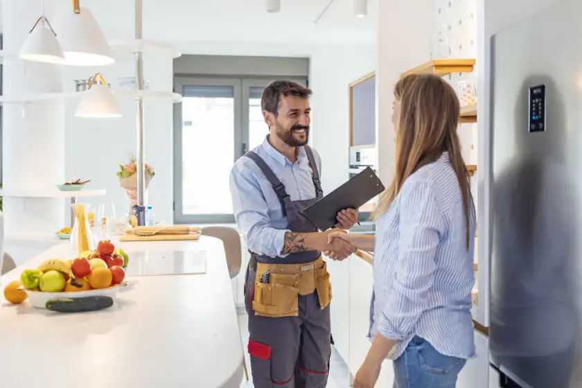Handwerker mit Frau steht in einer hellen Küche